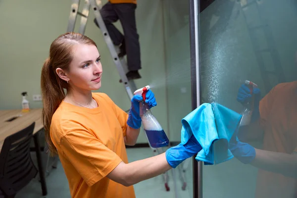 전문가 가창을 닦으면서 표면에 청소하는 액체를 뿌리는 — 스톡 사진