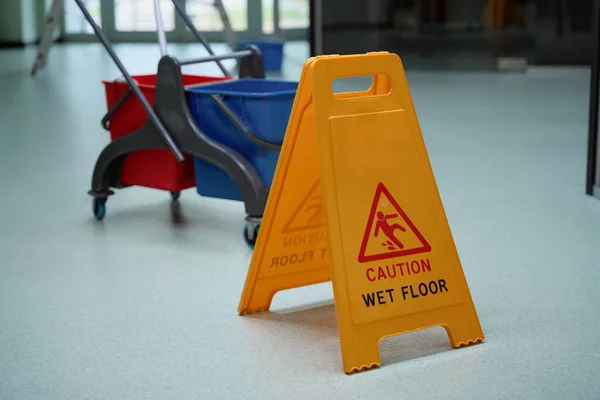 No people photo of a yellow caution sign placed on the wet floor after cleaning procedures