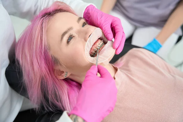 Ortodontist Pembe Saçlı Bir Kadın Hasta Için Diş Tellerini Düzeltiyor — Stok fotoğraf