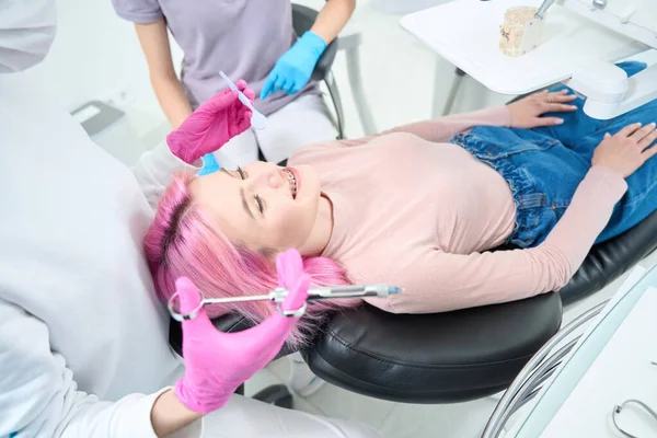 Pacjent Dżinsach Leży Krześle Dentystycznym Dentysta Przygotował Strzykawkę Znieczuleniem — Zdjęcie stockowe