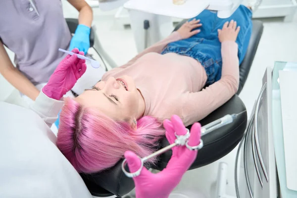 Kobieta Dżinsach Golfie Leży Fotelu Dentystycznym Dentysta Przygotował Strzykawkę Narkozą — Zdjęcie stockowe