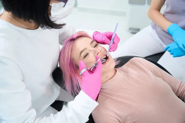 Młoda Kobieta Różowymi Włosami Znajduje Się Fotelu Dentystycznym Lekarz Znieczula — Zdjęcie stockowe