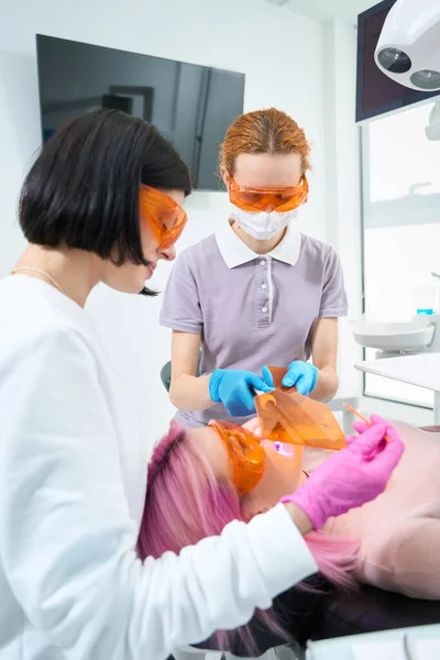 Mladá Žena Ochranných Brýlích Leží Zubním Křesle Lékař Asistentem Používá — Stock fotografie