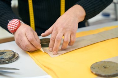 Terzi, ellerinin yakın çekim şeklini işaretliyor.