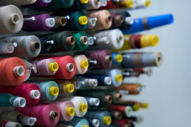 Özel tutucuların üzerinde çok renkli iplik makaraları var. Duvara güzelce tutturulmuşlar.