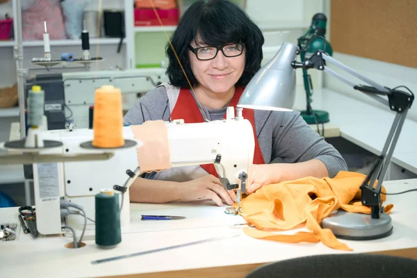 Pretty Woman Glasses Sits Sewing Machine She Works Yellow Fabric — Stock Photo, Image