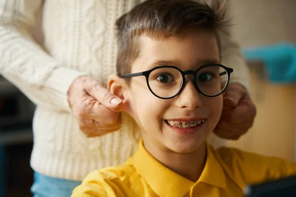 Niño Inteligente Con Gafas Sentado Mesa Mirando Cámara Cocina Abuela —  Fotos de Stock