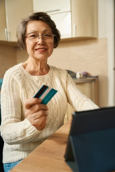 Γριά Γυναίκα Γυαλιά Κάθεται Στο Τραπέζι Tablet Κρατώντας Πιστωτική Κάρτα — Φωτογραφία Αρχείου