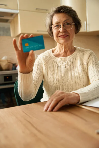 Γριά Κυρία Γυαλιά Κάθεται Στο Τραπέζι Κρατώντας Πιστωτική Κάρτα Και — Φωτογραφία Αρχείου