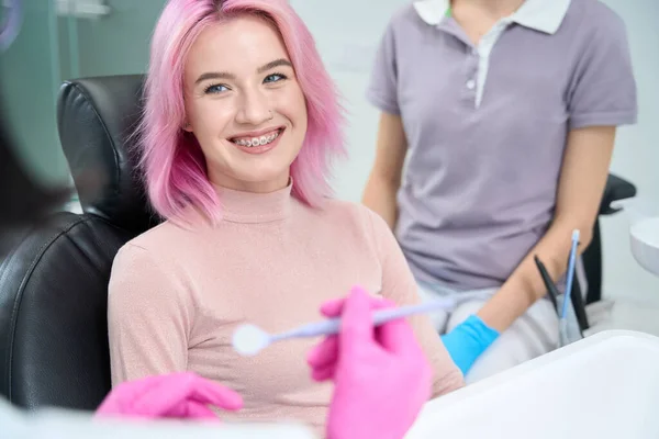 Młoda Kobieta Uśmiecha Się Uprzejmie Lekarza Demonstruje Swój System Wsporników — Zdjęcie stockowe