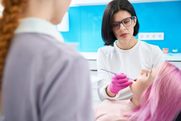 Dentiste Sérieux Procède Examen Approfondi Cavité Buccale Jeune Patient Assistant — Photo