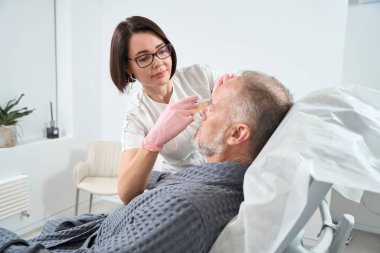 Doctor uses modern fillers for a rejuvenating course for an adult patient, the procedure takes place in comfortable conditions
