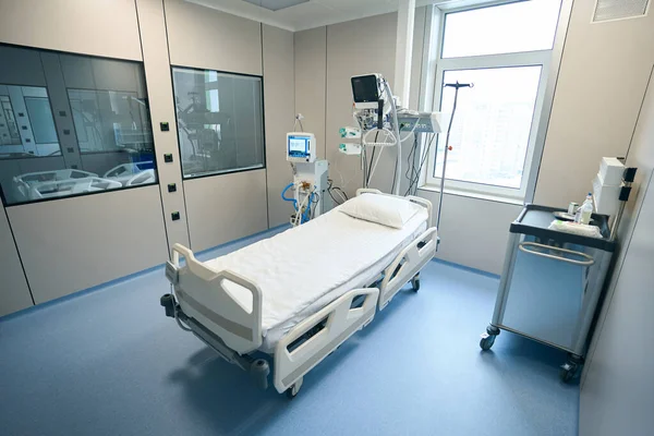 Photo of empty ward with bed and devices to support the life of patient in hospital