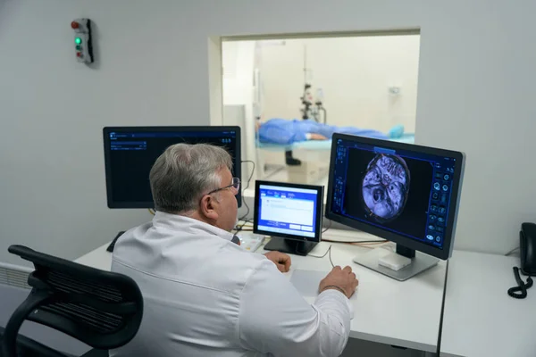Elderly Doctor Looks Monitor Diagnostic Equipment Examines Patient Brain — Stok fotoğraf