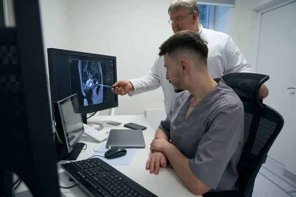 Two Doctors Examine Results Mri Monitor Experienced Colleague Points Localization — Stock fotografie