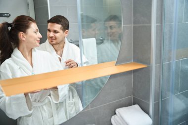 Young couple doing their morning routine in the bathroom, they brush their teeth together
