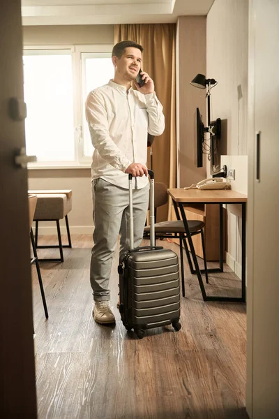 Guy Standing Hotel Room Travel Suitcase Talking Phone — Foto de Stock