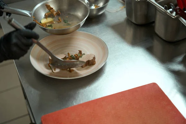 Kitchen Worker Puts Stewed Meat Mushrooms Vegetables Plate Appetizing Sauce — Fotografia de Stock
