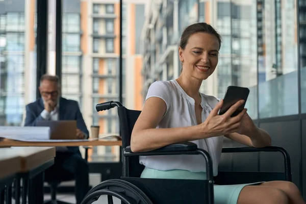 Υπάλληλος Αναπηρική Καρέκλα Μιλάει Στο Τηλέφωνο Συνάδελφός Της Κάθεται Στο — Φωτογραφία Αρχείου