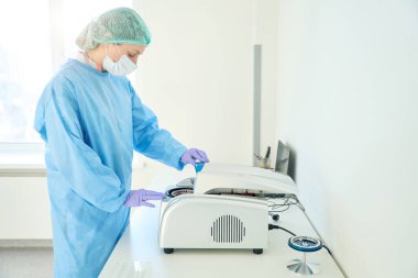 Hematologist puts samples into a centrifuge in a testing unit, this is a modern diagnostic laboratory