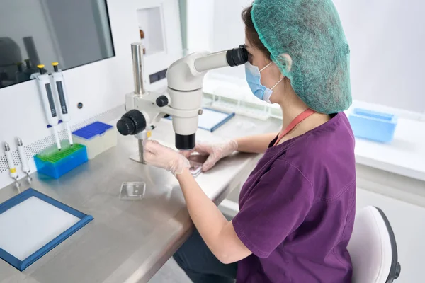 Woman Laboratory Assistant Overalls Protective Mask Looks Eyepiece Modern Microscope — Stockfoto