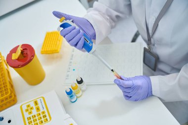 Doctor in the laboratory collects blood with a special dispenser, he conducts a blood group test