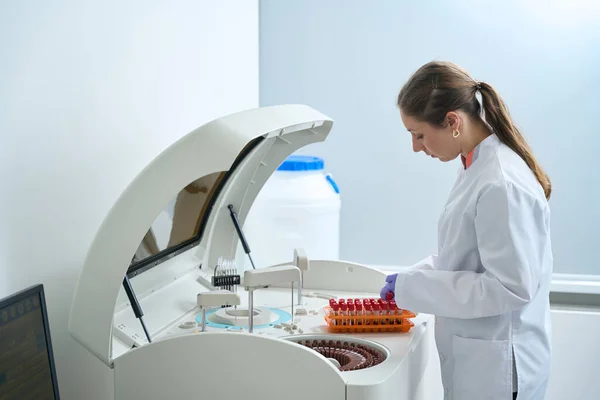 妇女在试验室进行实验室诊断 她使用现代生化分析仪 — 图库照片