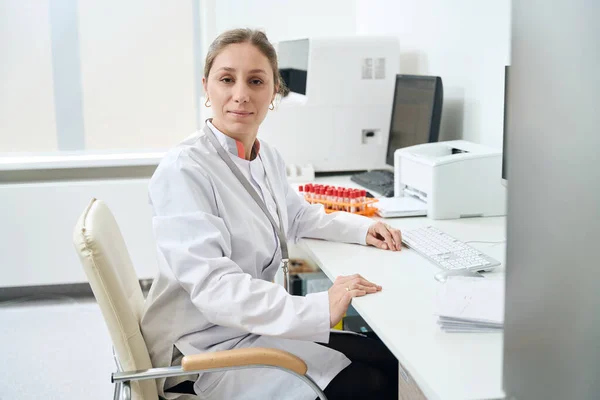 实验室的工作人员坐在她的办公桌前 她在试验室的试验室里 — 图库照片