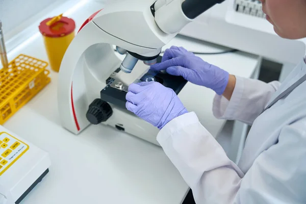 Female Laboratory Assistant Examines Sample Biomaterial Dna Test Microscope Laboratory — Stock fotografie