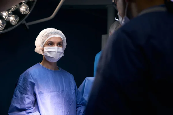 Mulher Uniforme Operativo Está Mesa Cirúrgica Lado Seus Colegas Médicos — Fotografia de Stock