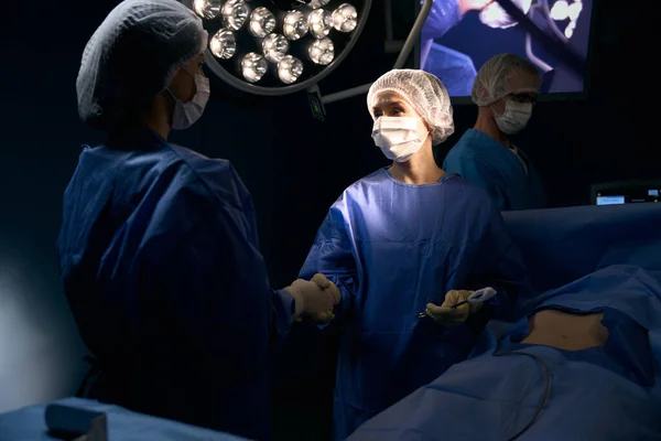 Handdruk Van Artsen Een Succesvolle Operatie Een Patiënt Ligt Operatietafel — Stockfoto