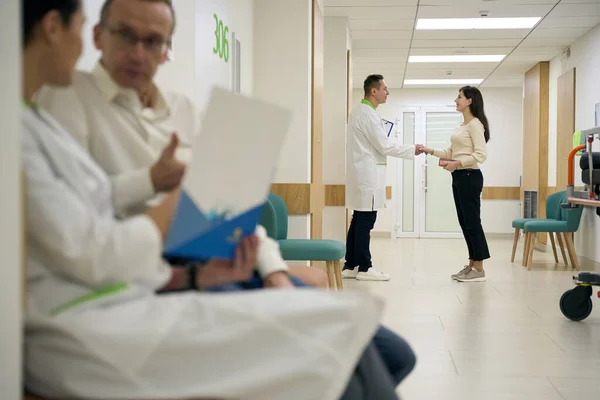 医生与病人在医院走廊的握手 男人与女人的交流 — 图库照片