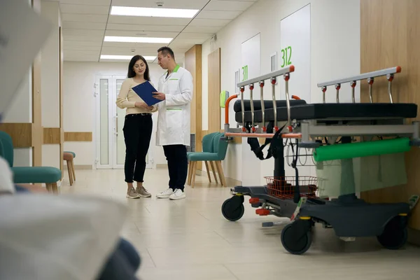 Uomo Operatore Sanitario Comunica Con Donna Nel Corridoio Dell Ospedale — Foto Stock