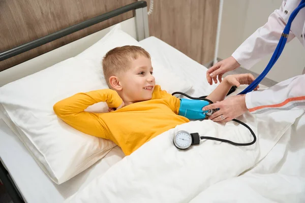 Zbliżenie Portret Szczęśliwego Schludnego Dziecka Łóżku Medycznym Podczas Badania Ciśnienia — Zdjęcie stockowe