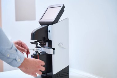 Göz hekimliği kliniğindeki çerçeveye göz lensleri yerleştirme sürecinin ayrıntılı resmi