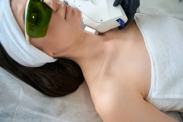 Mulher Óculos Proteção Deitada Sofá Cosmetologista Perto Fazendo Depilação Laser — Fotografia de Stock