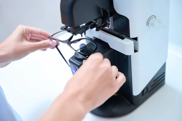 Close up picture of unrecognized person is making glasses by the modern ophthalmology machine