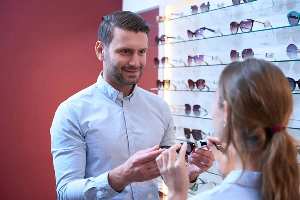 가게에 미남의 사진을 흔들며 여성들에게 선글라스를 있습니다 — 스톡 사진