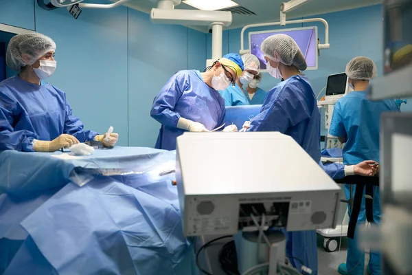 在一组专业人员进行外科手术的过程中 病人处于麻醉状态 — 图库照片