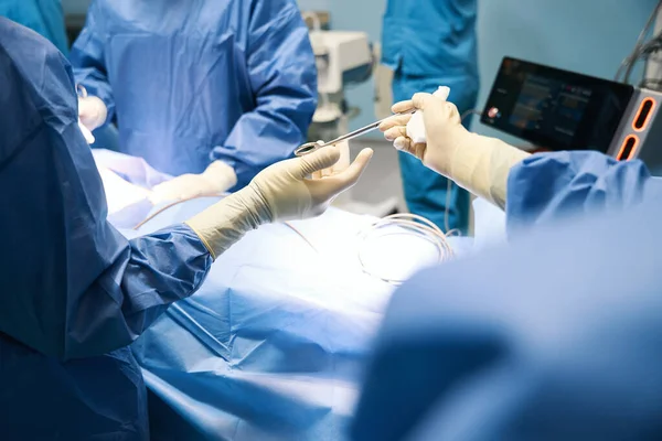 Muž Operačním Sále Předává Chirurgický Nástroj Kolegovi Lidé Chirurgické Uniformě — Stock fotografie