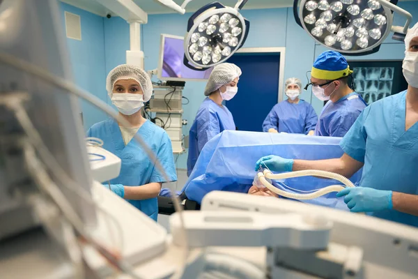 외과의 보조원들 수술대 수술실은 수술용 램프로 집니다 — 스톡 사진