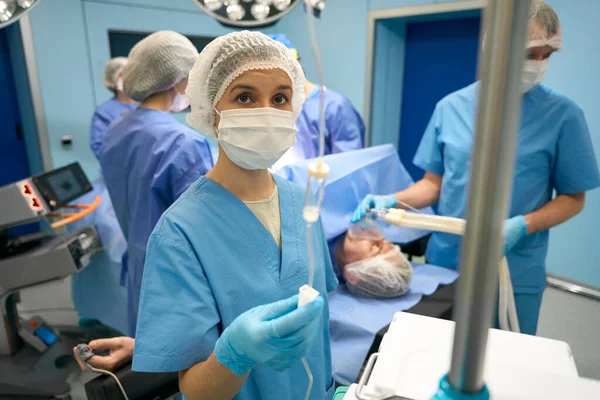 Asistent Kontroluje Průtok Léku Kapátkem Pacientovi Operačním Stole Pozadí Chirurgický — Stock fotografie