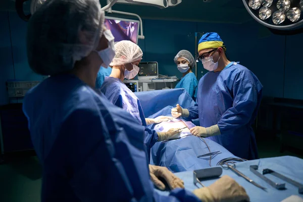 Paciente Sob Anestesia Jaz Mesa Cirurgia Uma Equipe Cirurgiões Trabalha — Fotografia de Stock