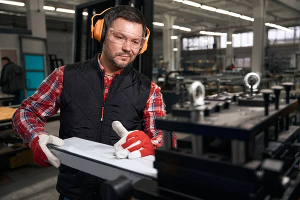 Uśmiechnięty Mężczyzna Ubraniach Ochronnych Rękawiczkach Instalujący Metalową Konstrukcję Maszynie Fabryce — Zdjęcie stockowe