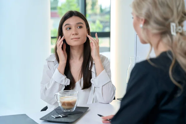 Молодая Женщина Сидит Столом Разговаривает Улыбающимся Доктором Кабинете Косметолога — стоковое фото
