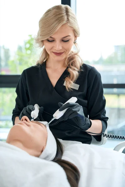 Kosmetikerin Schutzhandschuhen Sitzt Neben Erwachsener Frau Und Macht Thermolifting Therapie — Stockfoto