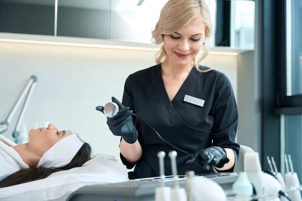 Kosmetologe Schutzhandschuhen Sitzt Mit Instrumenten Tisch Und Bereitet Sich Auf — Stockfoto