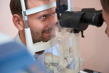 Yakından bakıldığında yakışıklı beyaz adamın portresi kesikli lamba içinde görüntü kontrolü yaparken yukarı bakıyor.