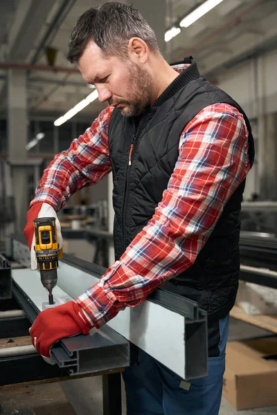 鉄構造と電気ドライバを使用して作業保護服や手袋の男性 — ストック写真