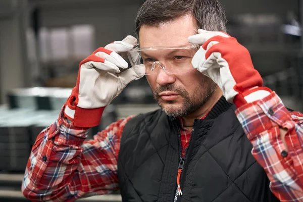 Zamknij Zdjęcie Dorosłego Mężczyzny Używającego Okularów Ochronnych Zakładzie Produkcji Konstrukcji — Zdjęcie stockowe